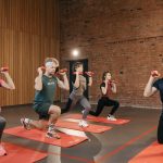 Indoor group workout session with dumbbells focusing on strength and fitness.