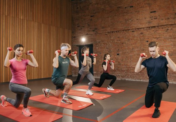 Indoor group workout session with dumbbells focusing on strength and fitness.