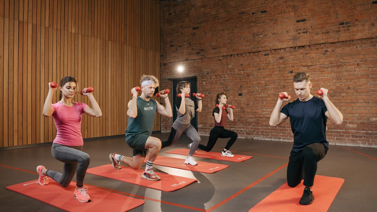 Indoor group workout session with dumbbells focusing on strength and fitness.